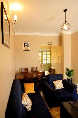 a living room with a blue couch and a dining room at Two-bedroom unit in Mubende Town in Mubende