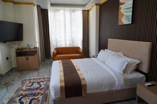 a hotel room with a large bed and a chair at Tara Haven Hotel in Yuwak