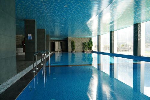 a large swimming pool with blue tiles on the ceiling at Tara Haven Hotel in Yuwak