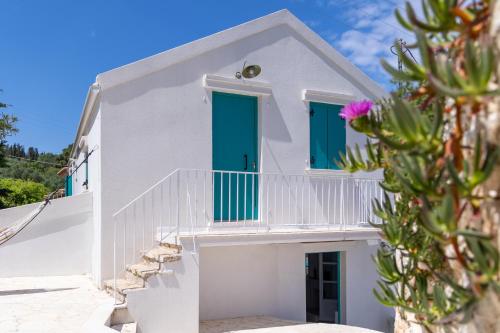 a white house with blue doors and stairs at Casa Calypso in Tselendáta