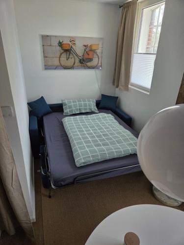 a small bedroom with a bed and a bike painting on the wall at Ferienwohnung Noltenius 2 in Bülstedt