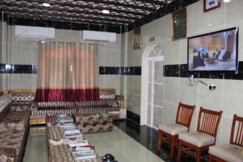 a dining room with tables and chairs and a tv at Five Continents Hotel in Sur