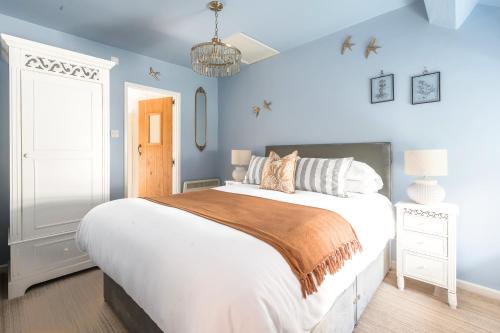 a bedroom with a large bed with blue walls at Stunning Cottage with free Spa access in Newby Bridge