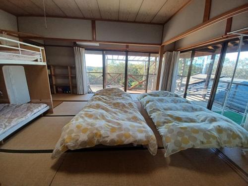 a bedroom with two beds and a large window at Cozy Koharuka in Shima