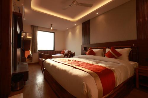 a bedroom with a large bed and a living room at RLS Hotels, Greater Noida Near Expo Centre & Mart in Greater Noida