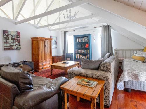 a living room with a couch and a table at Julie's Cottage in Riebeek-Kasteel
