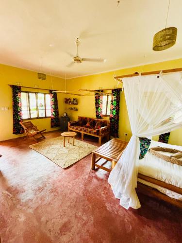 a living room with a bed and a couch at Casa Regina in Vilanculos