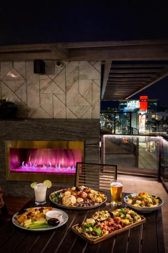 a table with three plates of food and a fireplace at Hollywood Penthouse with Balcony Pool and Hollywood sign View with Free parking in Los Angeles