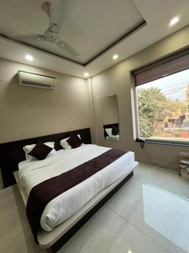 a bedroom with a large bed and a window at Hotel Golden Olive in Kurukshetra