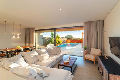 a living room with a white couch and a table at Aethrion Villas & Suites in Gennadi