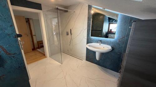 a bathroom with a sink and a glass shower at Alpin-Check-in in Reutte