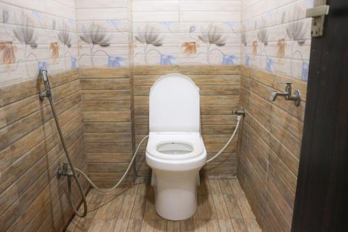 a bathroom with a white toilet in a stall at Kanha Gold in Bhopal