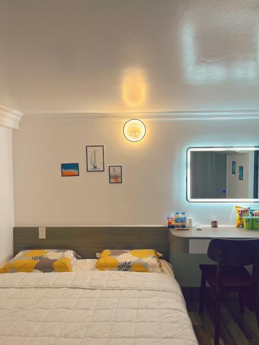 a bedroom with a bed and a desk and a bed sidx sidx sidx at Êm Attic Hai Phong Old Town in Hai Phong