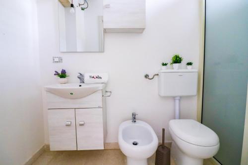 a bathroom with a toilet and a sink and a mirror at Elaia's House in Cannole in Cannole
