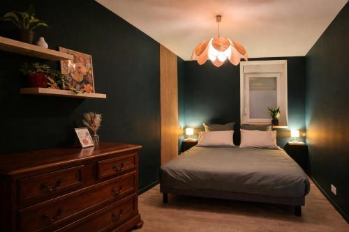a bedroom with a bed and a chandelier at L'Atelier de l'Émeraude in Saverne