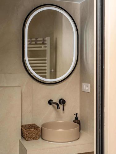 a bathroom with a sink and a mirror on the wall at Distinct Ultracentral Apartment in Bistriţa
