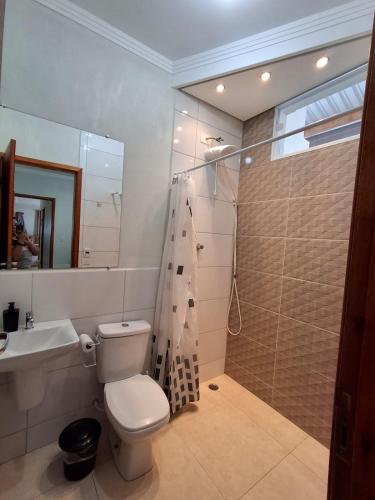 a bathroom with a toilet and a shower and a sink at Chácara Recanto JJ in Sorocaba