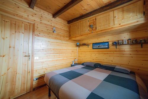 a bedroom with a bed in a wooden cabin at Campeggio Beaulard in Beaulard