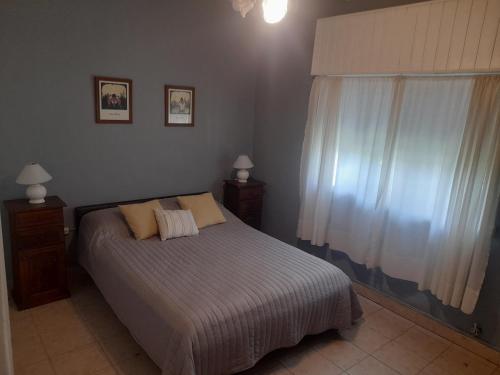 a bedroom with a bed with two pillows and a window at Quinta Las Violetas in Mercedes