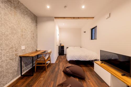 a bedroom with a bed and a desk at Innocence Resort -in Chiba Resol- in Hasunuma