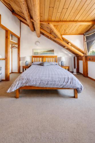 a large bedroom with a bed and wooden ceilings at Yallingup Surfing wineries and restaurants in Yallingup