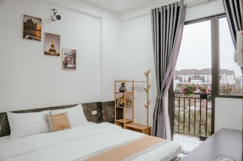 a bedroom with a bed and a large window at DeHa Homestay in Kon Rung (1)