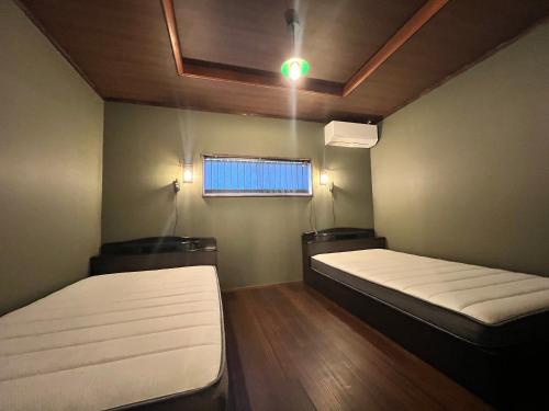 a room with two beds and a window in it at 季紀の杜阿蘇 in Aso