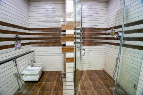 a bathroom with a toilet and a shower at The Royal Comfort in Bangalore