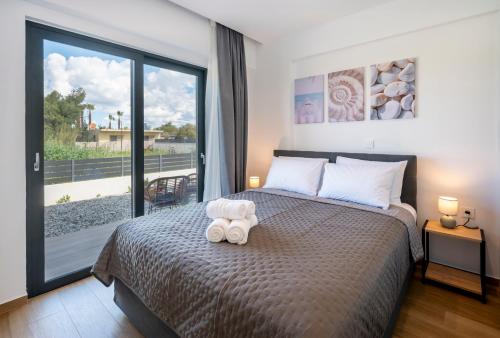 a bedroom with a bed and a large window at Odaria Premium Apartments in Lampi