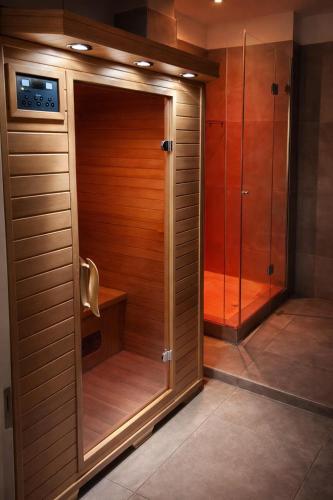 a walk in shower in a bathroom with wooden cabinets at Favorite Room&Spa in San Giuseppe Vesuviano