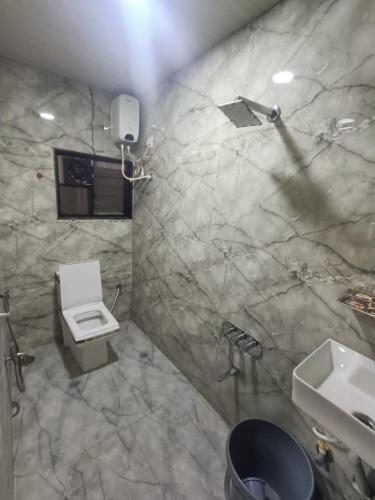 a bathroom with a white toilet and a sink at Shree Nagnath Residency in Ellora