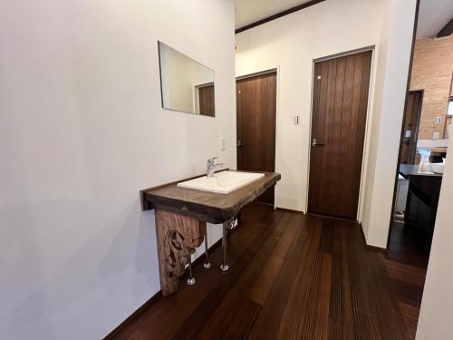 a bathroom with a sink and a mirror on the wall at 季紀の杜阿蘇 in Aso