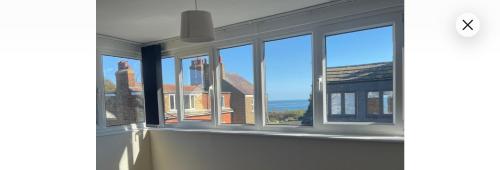 a room with windows with a view of the ocean at Hope Corner in Filey