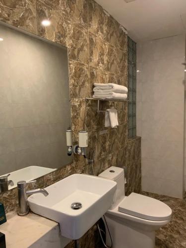 a bathroom with a sink and a toilet and a mirror at Golden Villa in Hanoi