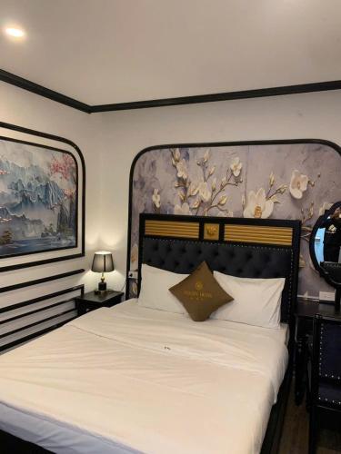 a bedroom with a large white bed with a large headboard at Golden Villa in Hanoi
