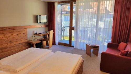 a hotel room with a bed and a chair and a window at Speidel´s BrauManufaktur in Ödenwaldstetten