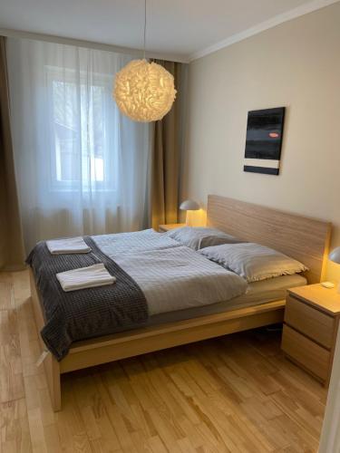 a bedroom with a bed and a chandelier at Sóstó Liget House in Igricetanya