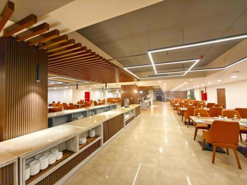 a restaurant with tables and chairs and a cafeteria at Hotel Grand Pacific in Cox's Bazar