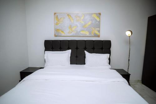 a bedroom with a large bed with white sheets at Buffalo Village in Kigali