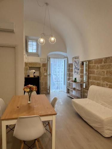 a living room with a table and a couch at Marbella house con jacuzzi in Polignano a Mare