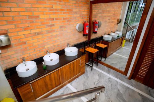 a bathroom with two sinks and a red fire extinguisher at Buffalo Village in Kigali
