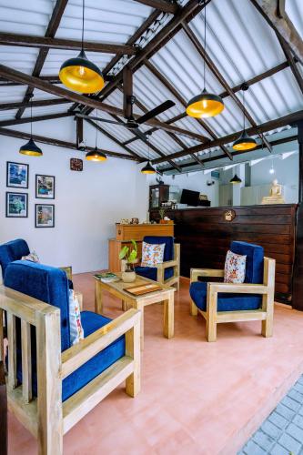 a lobby with blue chairs and tables and lights at Glamour Mirissa in Mirissa