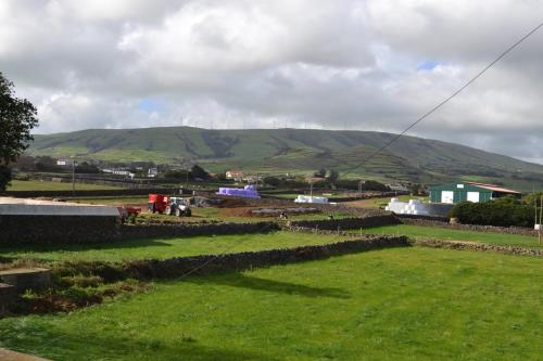a green field with a mountain in the background at Casa de Santa Catarina in Cabo da Praia