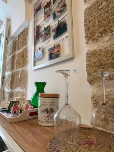 two wine glasses sitting on top of a counter at Marbella house con jacuzzi in Polignano a Mare