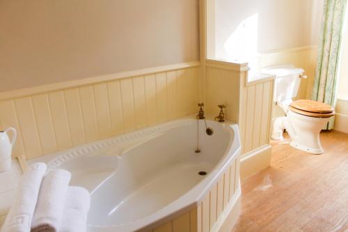 a bathroom with a large tub and a toilet at Penmorvah Manor Hotel in Falmouth