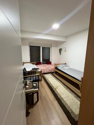 a room with two beds and a table in it at Famely apartmen in Prizren