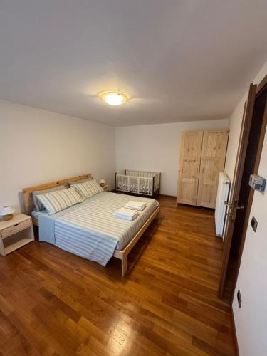a bedroom with a bed and a wooden floor at Alloggio ai Campanari in Conco