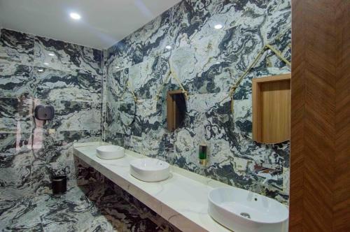a bathroom with two sinks and a marble wall at SUNSET HOTEL in Nouakchott