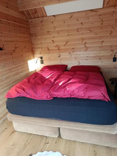 a bed in a room with a wooden wall at Holzhaus Riegersburg in Riegersburg