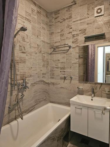 a bathroom with a tub and a sink at Apartment Pasha in Pržno